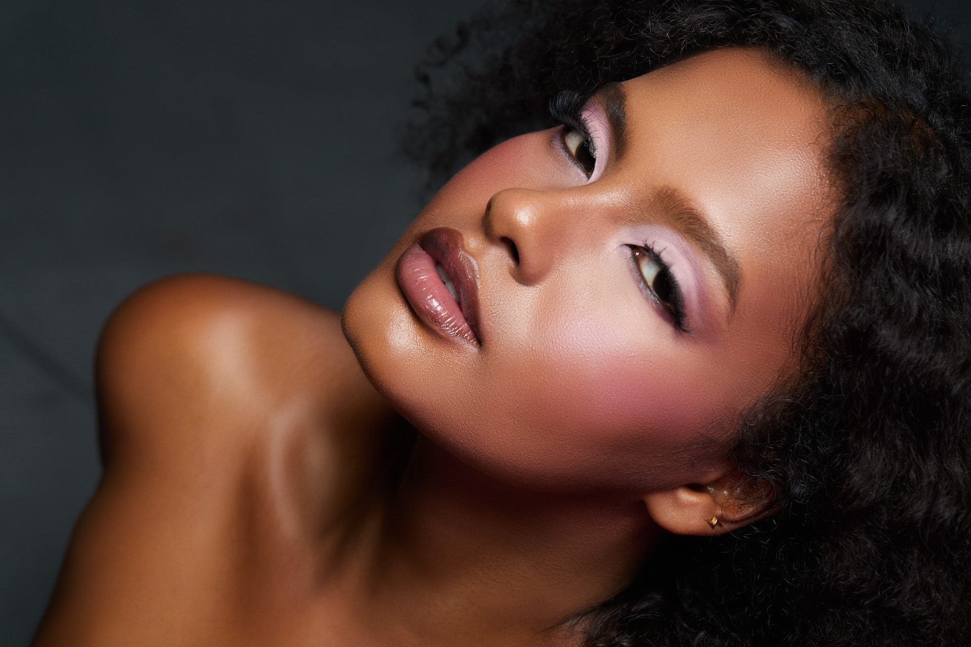 Editorial close up with blush-flushed cheeks and glossy nude lips